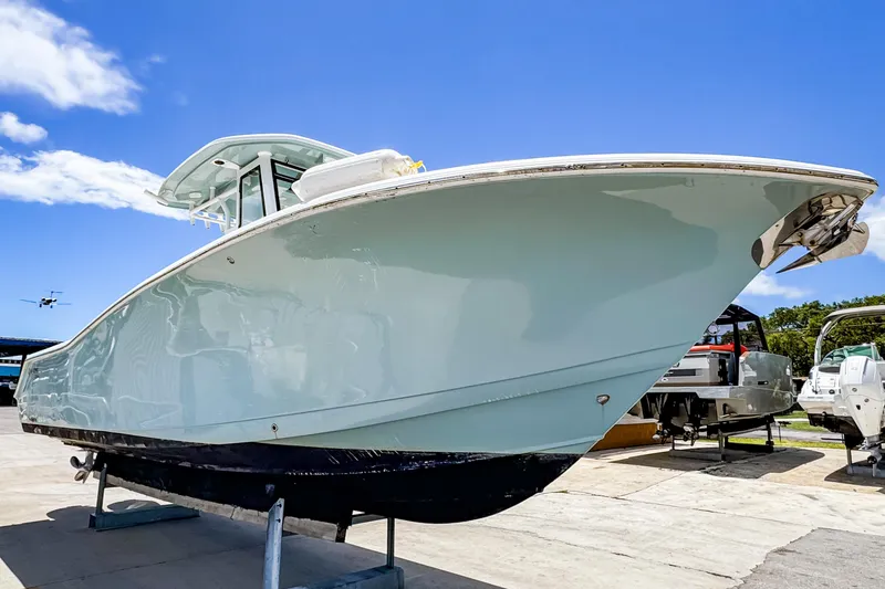 Slide: The Image of 2023 Tidewater 280 CC Adventure boat displayed outdoors under clear blue sky. - 3