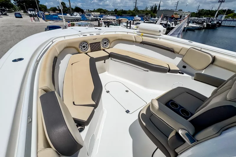 Slide: The Image of 2023 Tidewater 280 CC Adventure boat interior with beige seating and cup holders. - 31