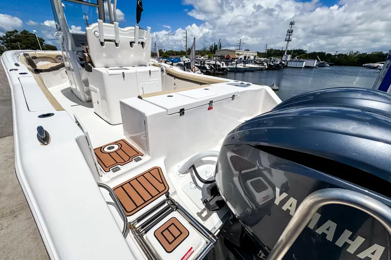 Slide: The Image of 2023 Tidewater 280 CC Adventure boat with Yamaha engines docked by the water. - 6