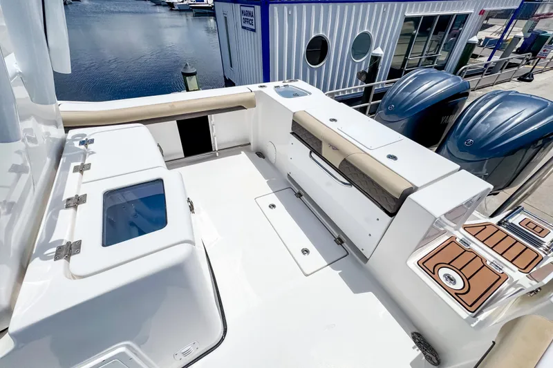 Slide: The Image of 2023 Tidewater 280 CC Adventure boat interior with seating and storage at marina. - 7