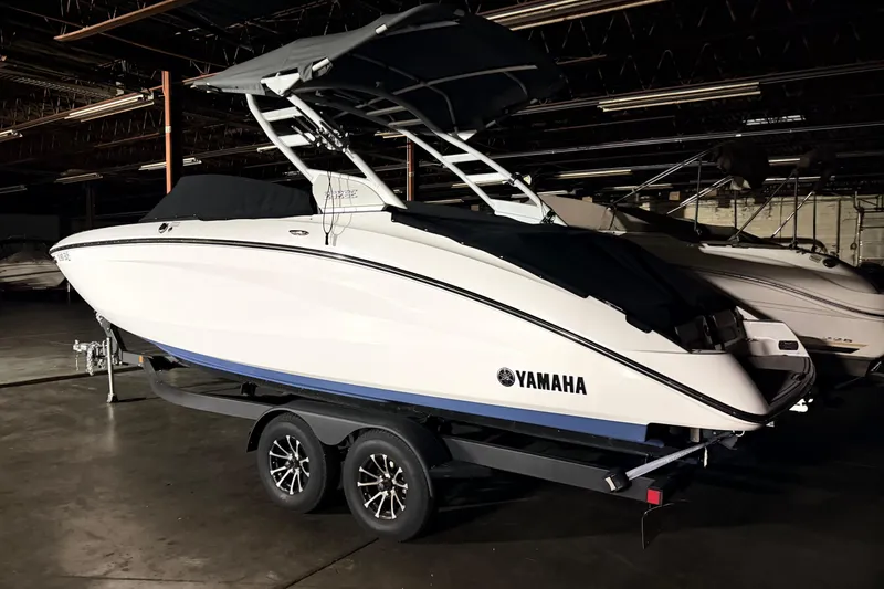 Slide: The Image of 2023 Yamaha Boats 252SE in a dimly lit showroom on a trailer. - 1