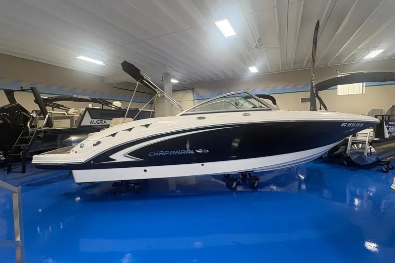 Slide: The Image of 2012 Chaparral 244 Sunesta boat displayed indoors on a blue floor. - 1