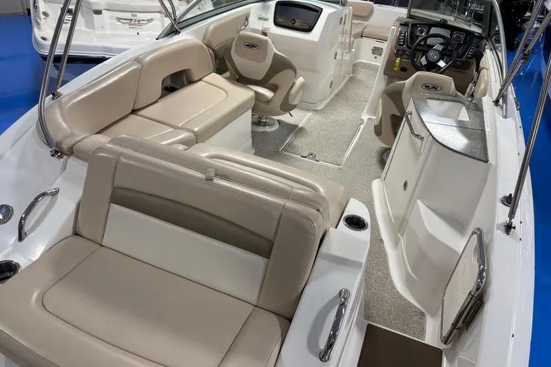 Slide: The Image of 2012 Chaparral 244 Sunesta boat interior with beige seating and modern dashboard. - 10