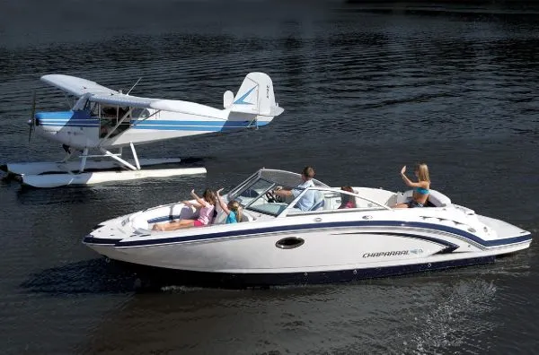 Slide: The Image of Manufacturer Provided Image: 2012 Chaparral 244 Sunesta boat on water near a seaplane. - 14