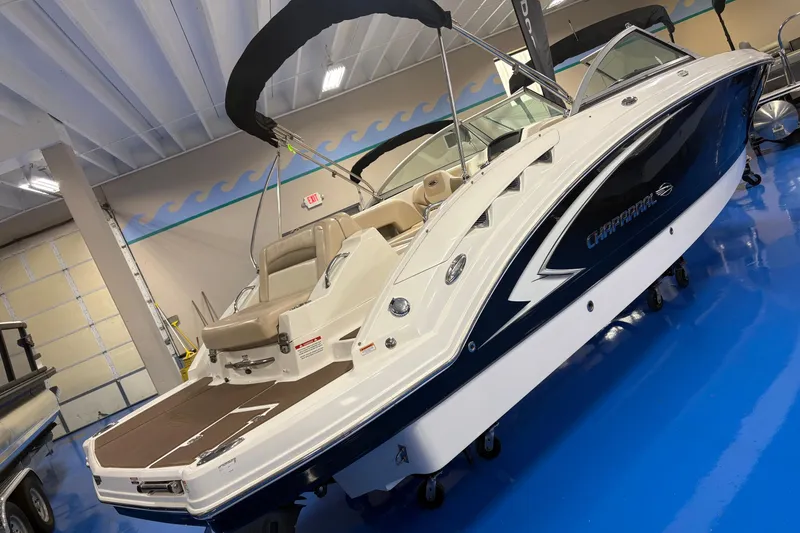 Slide: The Image of 2012 Chaparral 244 Sunesta boat displayed indoors on a blue floor. - 2