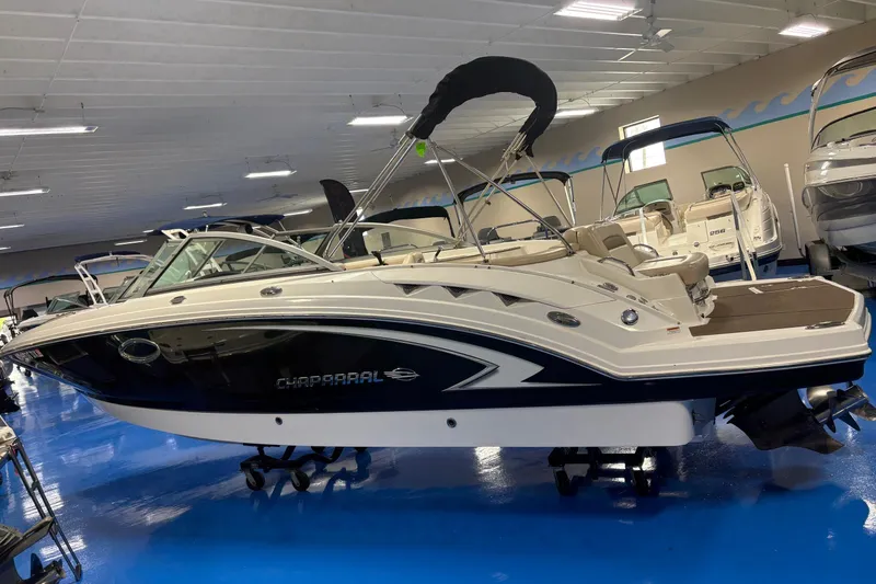 Slide: The Image of 2012 Chaparral 244 Sunesta boat displayed indoors on a blue floor. - 3