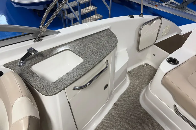 Slide: The Image of 2012 Chaparral 244 Sunesta boat interior with sink and seating area. - 6