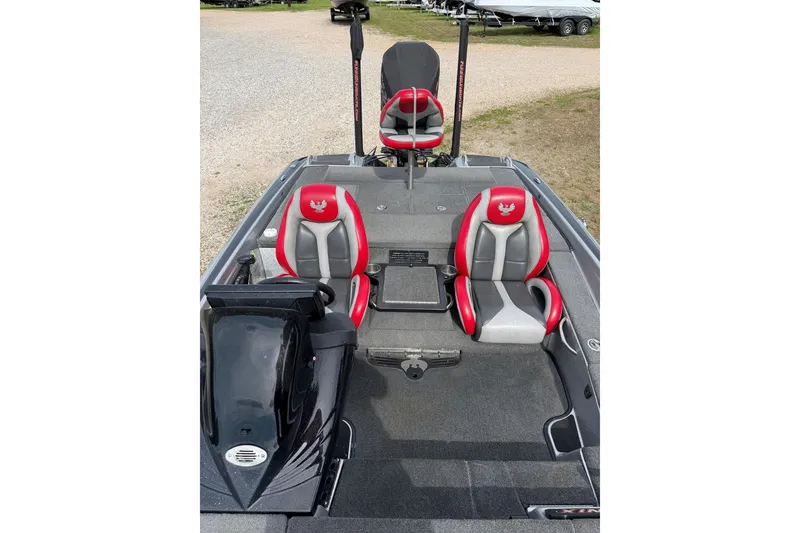 Slide: The Image of 2019 Phoenix 920 ProXP boat interior with red and gray seats, parked outdoors. - 5
