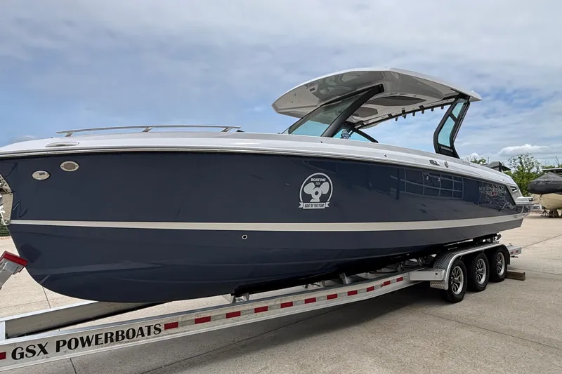 Slide: The Image of 2026 Monterey Elite 30 OB boat on trailer, sleek design, blue hull, outdoor setting. - 3