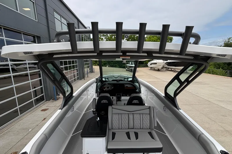 Slide: The Image of 2026 Monterey Elite 30 OB boat interior with modern seating and helm, docked near a building. - 31
