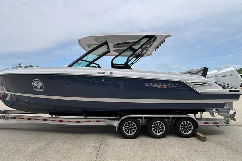 Slide: The Image of 2026 Monterey Elite 30 OB boat on trailer, side view, with Mercury engines. - 4