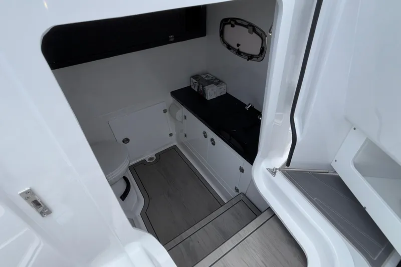 Slide: The Image of Interior of 2026 Monterey Elite 30 OB boat, featuring a compact bathroom space. - 66