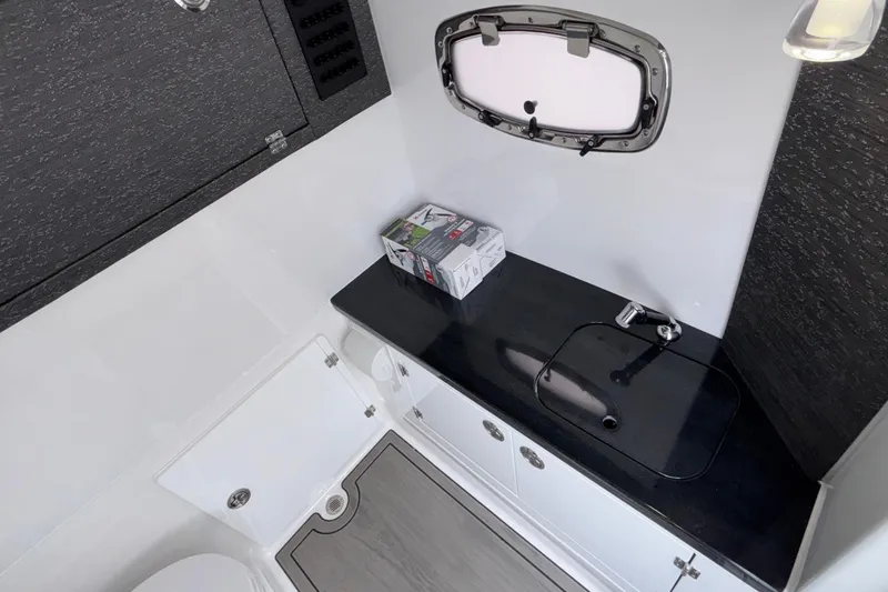 Slide: The Image of 2026 Monterey Elite 30 OB boat bathroom with sleek black countertop and modern fixtures. - 69