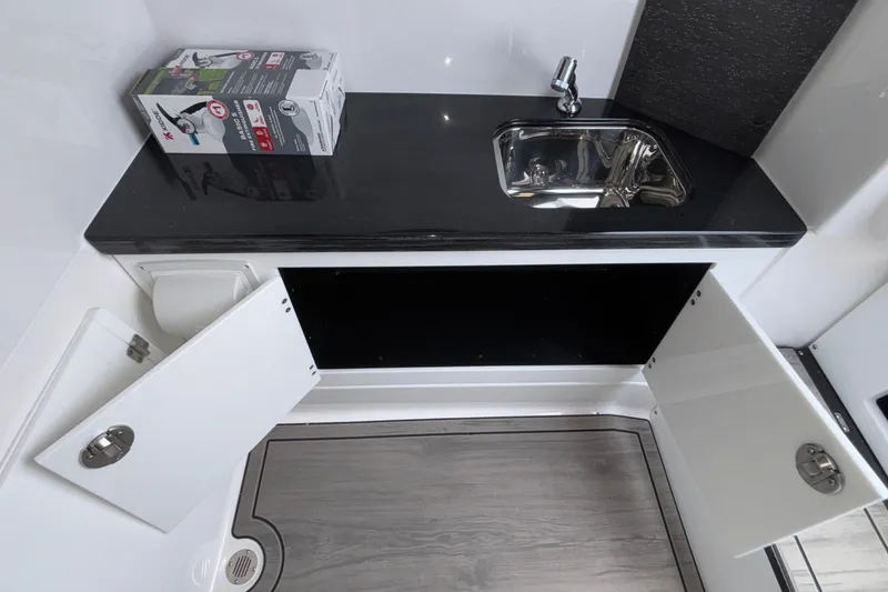 Slide: The Image of Modern kitchenette in 2026 Monterey Elite 30 OB boat with sink and storage cabinets. - 74