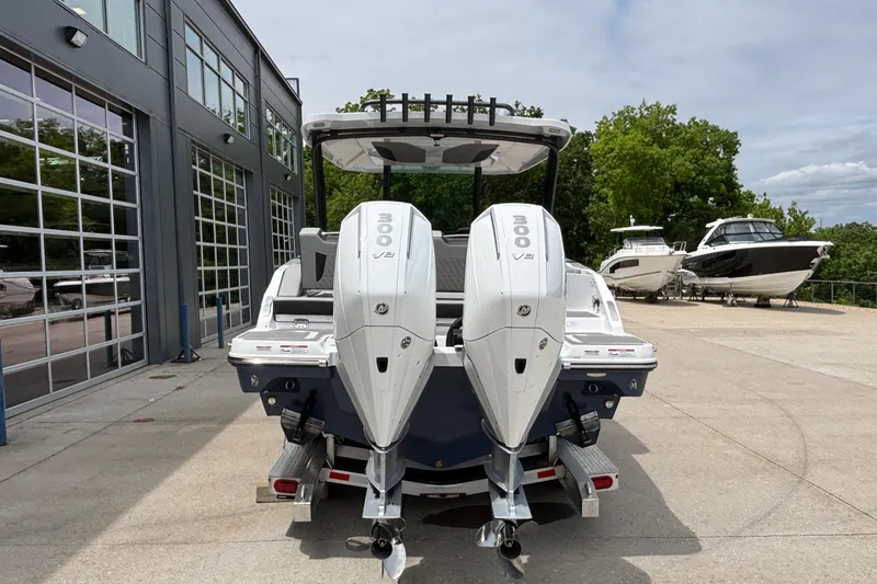 Slide: The Image of 2026 Monterey Elite 30 OB boat with dual 300 V8 engines, parked outdoors. - 93