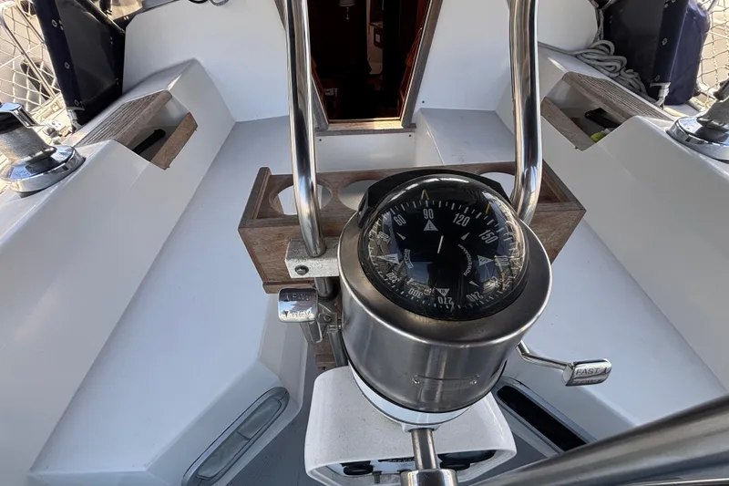 Slide: The Image of Cockpit of a 1990 Catalina 42 sailboat featuring a compass and steering wheel. - 12