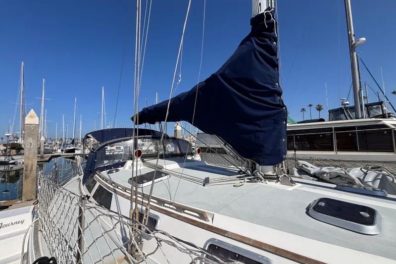 Slide: The Image of Sailboat Catalina 42, 1990 model, docked at marina under clear blue sky. - 2
