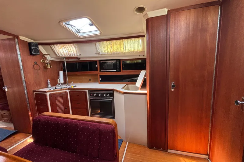 Slide: The Image of Interior of a 1990 Catalina 42 sailboat with wood paneling and kitchen area. - 23
