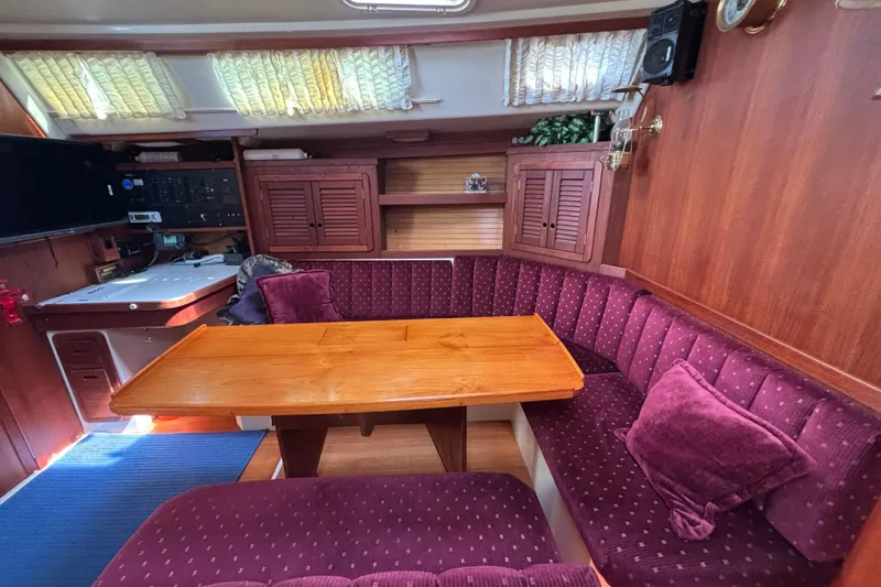 Slide: The Image of Interior of a 1990 Catalina 42 sailboat with plush seating and wooden table. - 24
