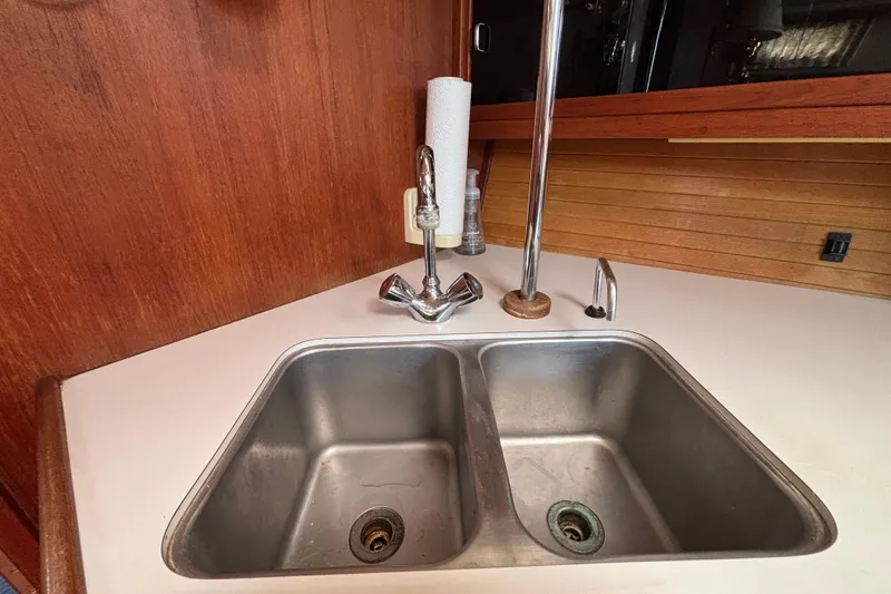 Slide: The Image of 1990 Catalina 42 yacht kitchen sink with dual basins and wooden cabinetry. - 26