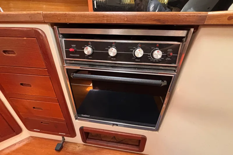 Slide: The Image of Stove and oven in 1990 Catalina 42 yacht kitchen, featuring wooden cabinetry. - 28