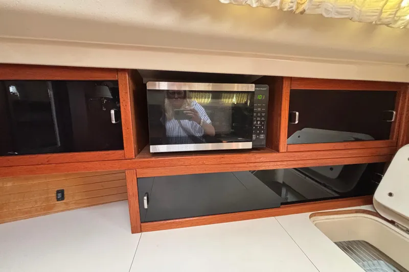 Slide: The Image of Interior of 1990 Catalina 42 yacht with microwave and wooden cabinetry. - 29