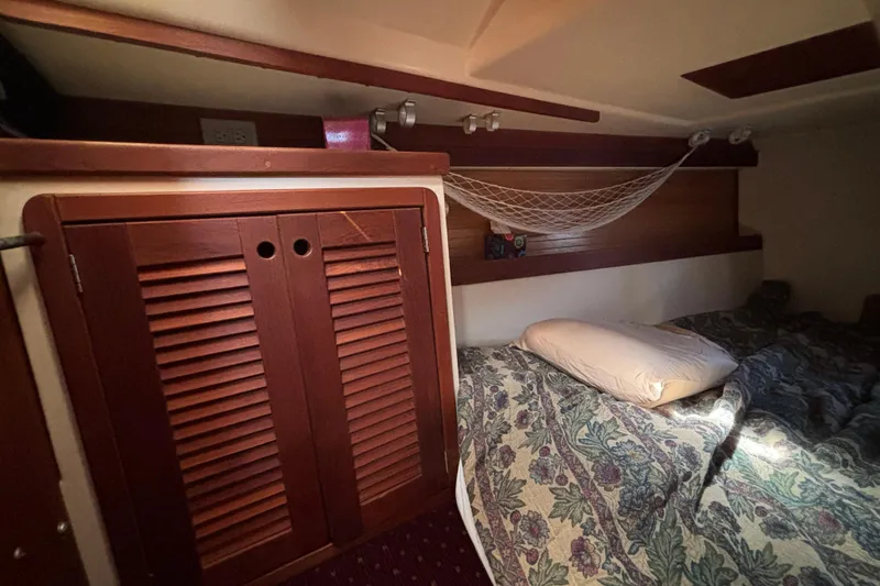 Slide: The Image of Cozy cabin interior of 1990 Catalina 42 sailboat with bed and wooden storage. - 33
