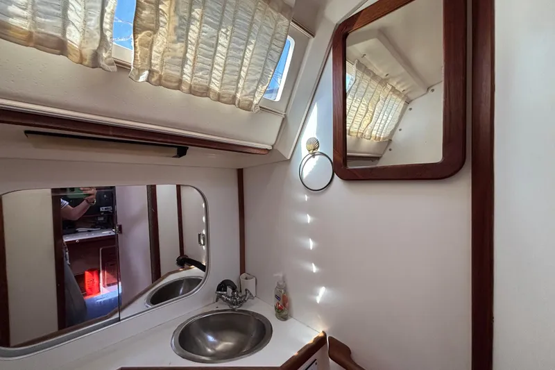 Slide: The Image of Bathroom interior of a 1990 Catalina 42 sailboat with mirrors and sink. - 37