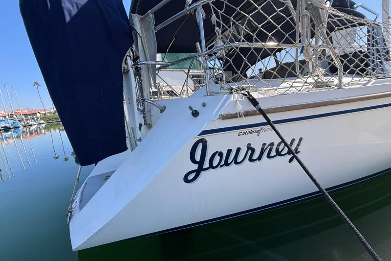 Slide: The Image of 1990 Catalina 42 sailboat named "Journey" docked in a marina. - 6