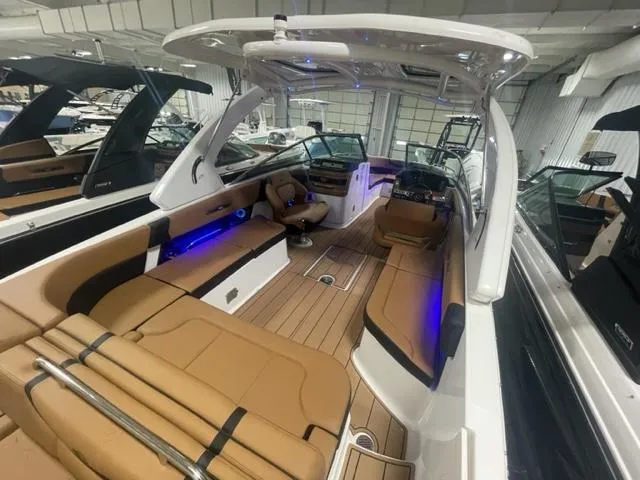 Slide: The Image of 2023 Chaparral 307 SSX boat interior with tan seating and blue LED lighting. - 10