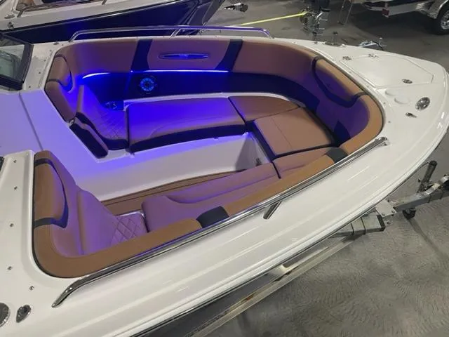 Slide: The Image of 2023 Chaparral 307 SSX boat interior with tan seating and blue LED lighting. - 12