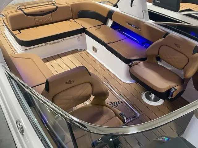 Slide: The Image of 2023 Chaparral 307 SSX boat interior with tan leather seating and blue LED lighting. - 14