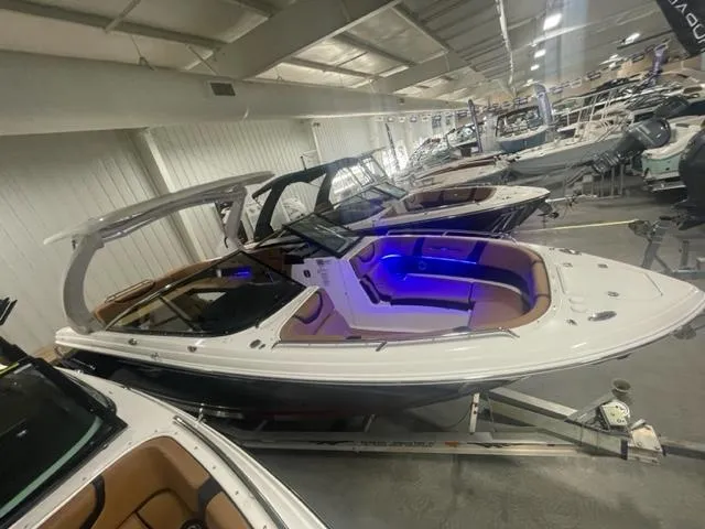 Slide: The Image of 2023 Chaparral 307 SSX boat in showroom with blue interior lighting. - 15