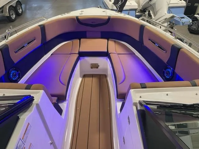 Slide: The Image of 2023 Chaparral 307 SSX boat interior with tan and black seating, blue LED lighting. - 3