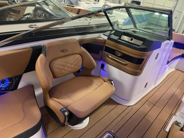 Slide: The Image of 2023 Chaparral 307 SSX boat interior with tan leather seats and modern dashboard. - 4