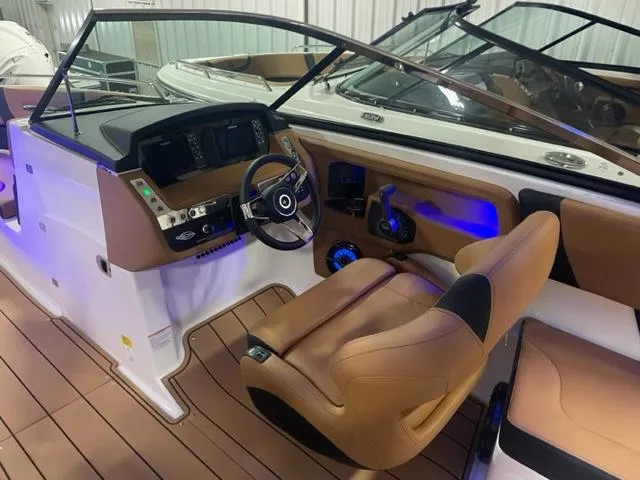Slide: The Image of 2023 Chaparral 307 SSX boat interior with modern dashboard and tan seating. - 5