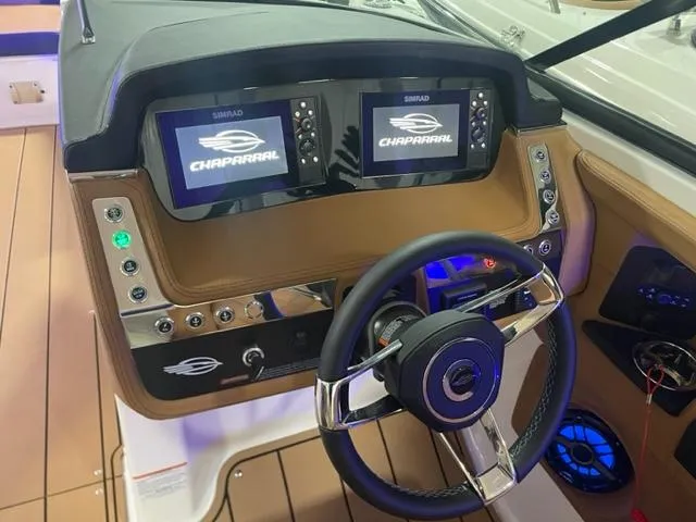 Slide: The Image of 2023 Chaparral 307 SSX boat dashboard with dual Simrad displays and steering wheel. - 6