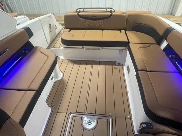 Slide: The Image of 2023 Chaparral 307 SSX boat interior with tan and black seating, blue LED lighting. - 7