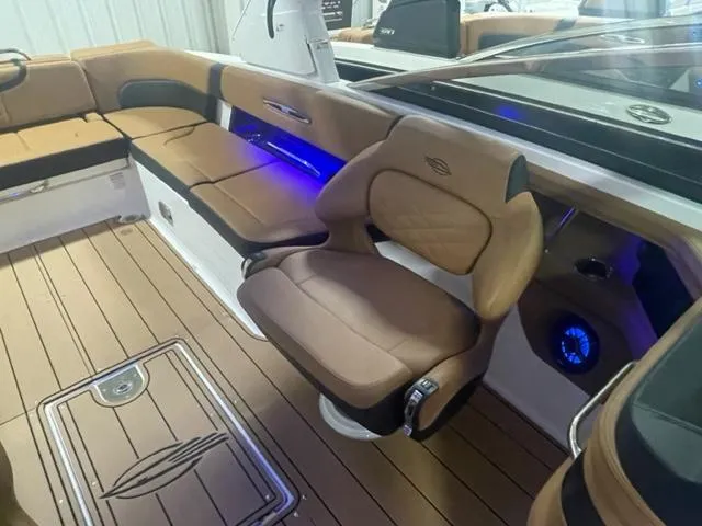 Slide: The Image of 2023 Chaparral 307 SSX boat interior with tan seating and blue LED lighting. - 8