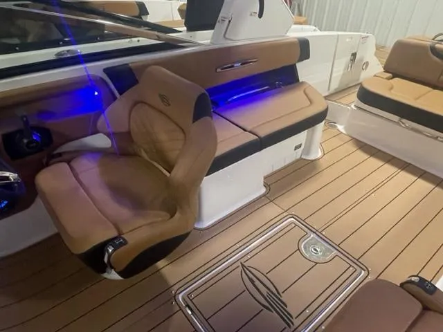 Slide: The Image of Interior of 2023 Chaparral 307 SSX boat with tan seating and blue LED lighting. - 9