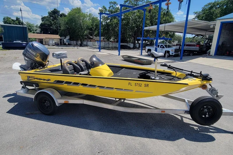 Slide: The Image of Yellow 2011 Excel 1751 F4 boat on trailer with Yamaha motor, parked outdoors. - 3