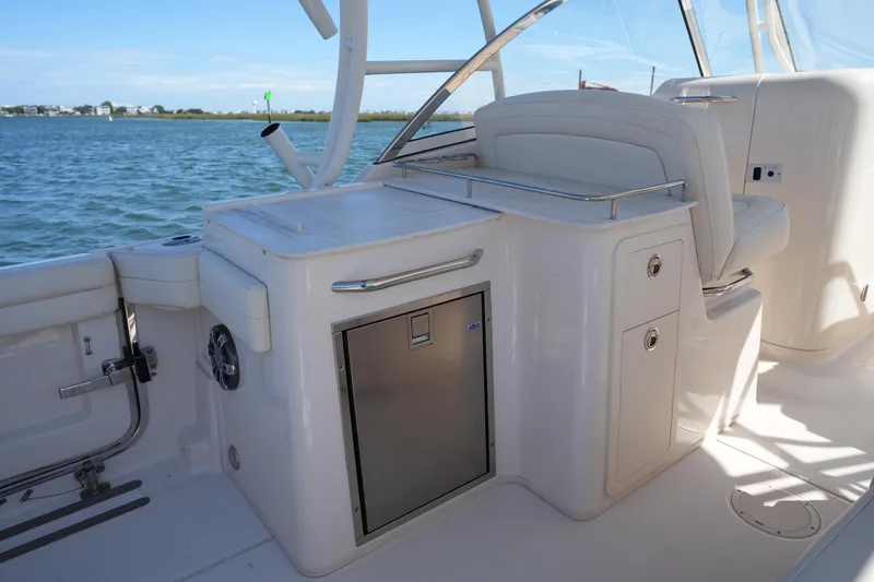 Slide: The Image of 2022 Grady-White Freedom 285 boat interior with seating and storage, on a sunny day. - 15