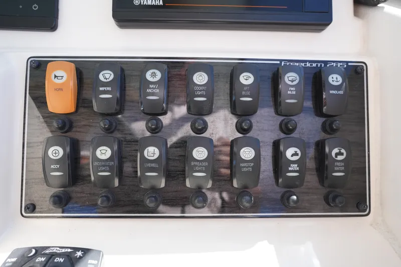 Slide: The Image of Control panel of a 2022 Grady-White Freedom 285 boat with labeled switches. - 26