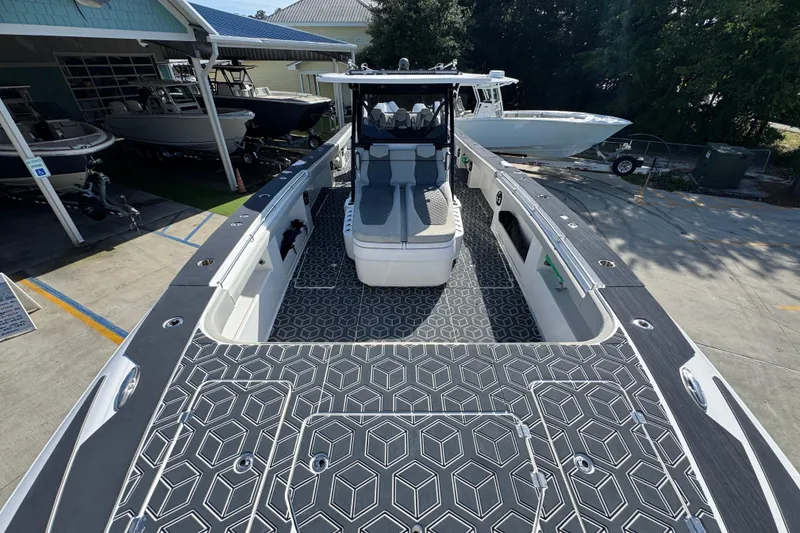 Slide: The Image of 2022 Invincible 46 Catamaran with geometric deck design, docked at a marina. - 14