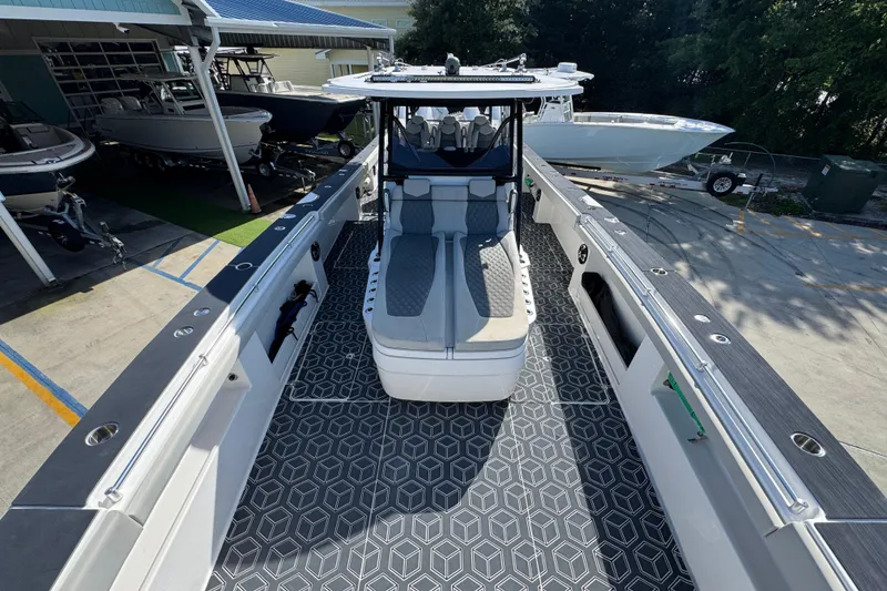 Slide: The Image of 2022 Invincible 46 Catamaran with sleek design and spacious deck, docked at a marina. - 15
