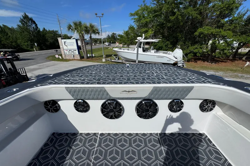 Slide: The Image of 2022 Invincible 46 Catamaran with geometric deck design and modern speakers, docked outdoors. - 18