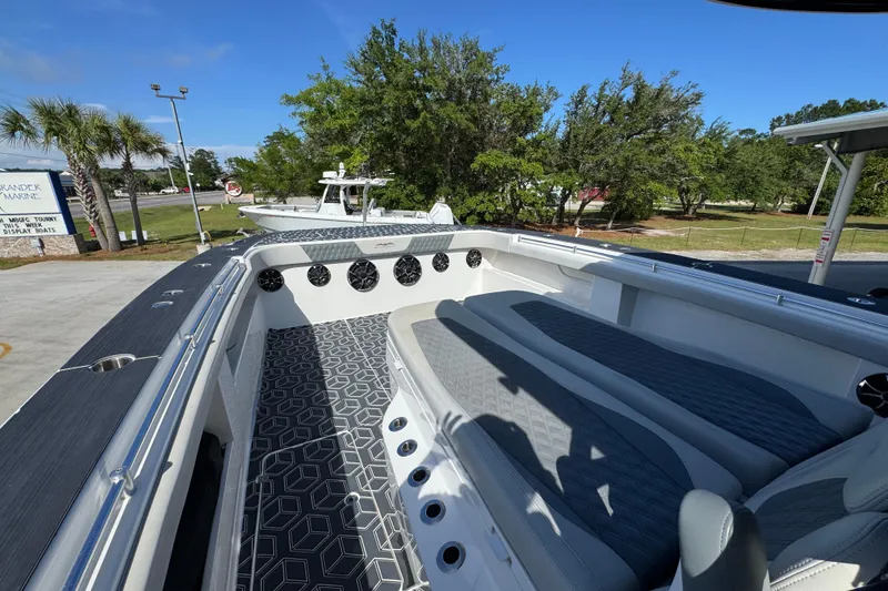 Slide: The Image of 2022 Invincible 46 Catamaran with sleek seating and modern design in a marina setting. - 19