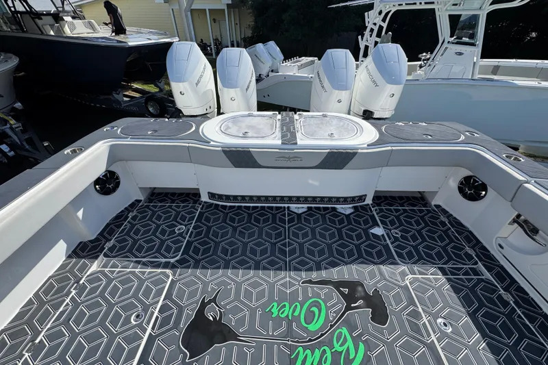 Slide: The Image of 2022 Invincible 46 Catamaran deck with geometric flooring and four Mercury outboard engines. - 41