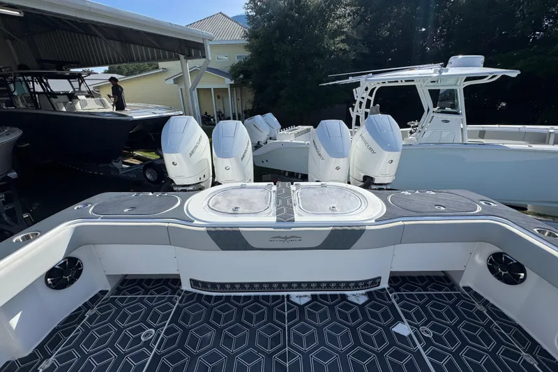 Slide: The Image of 2022 Invincible 46 Catamaran with quad Mercury engines, docked under a shelter. - 43