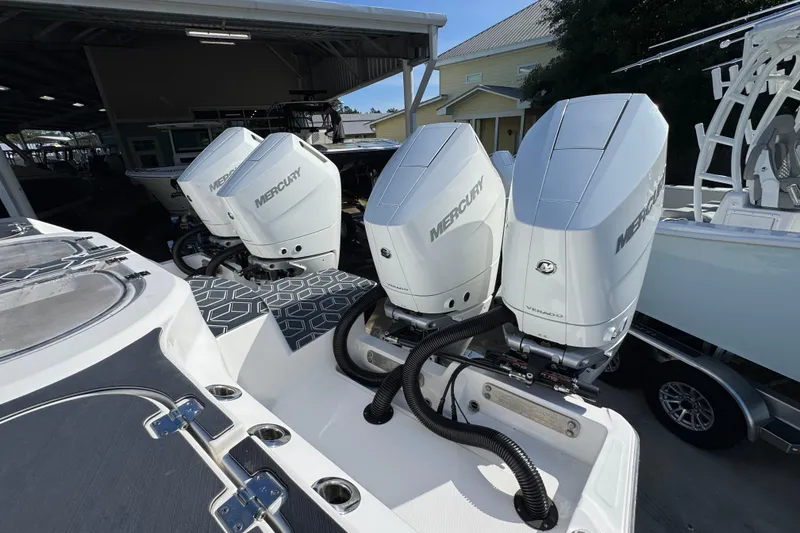 Slide: The Image of Triple Mercury outboard engines on a 2022 Invincible 46 Catamaran, docked under a shelter. - 45